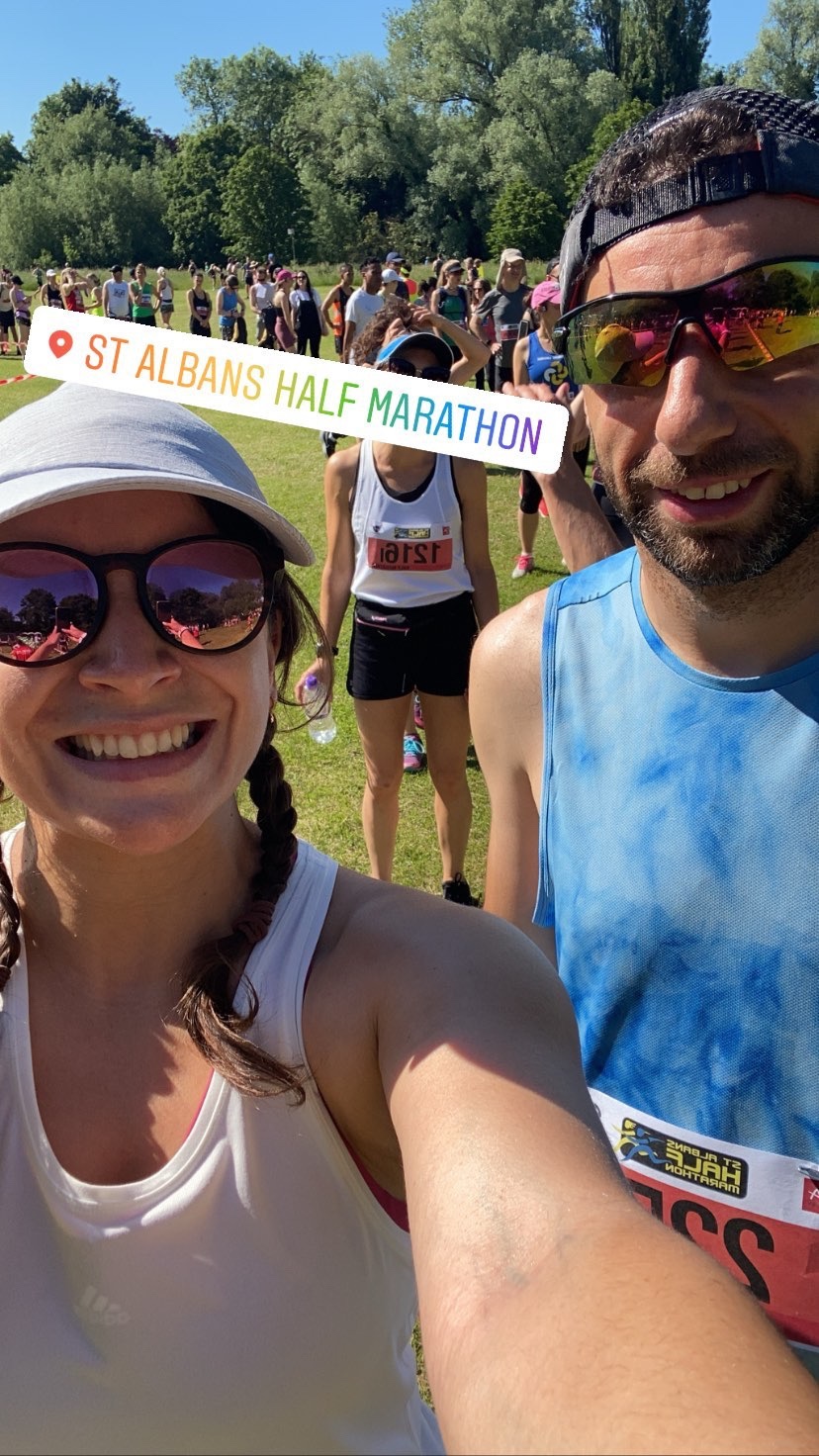 A selfie of two people, a man and a woman, wearing sunglasses on a sunny day in a field 