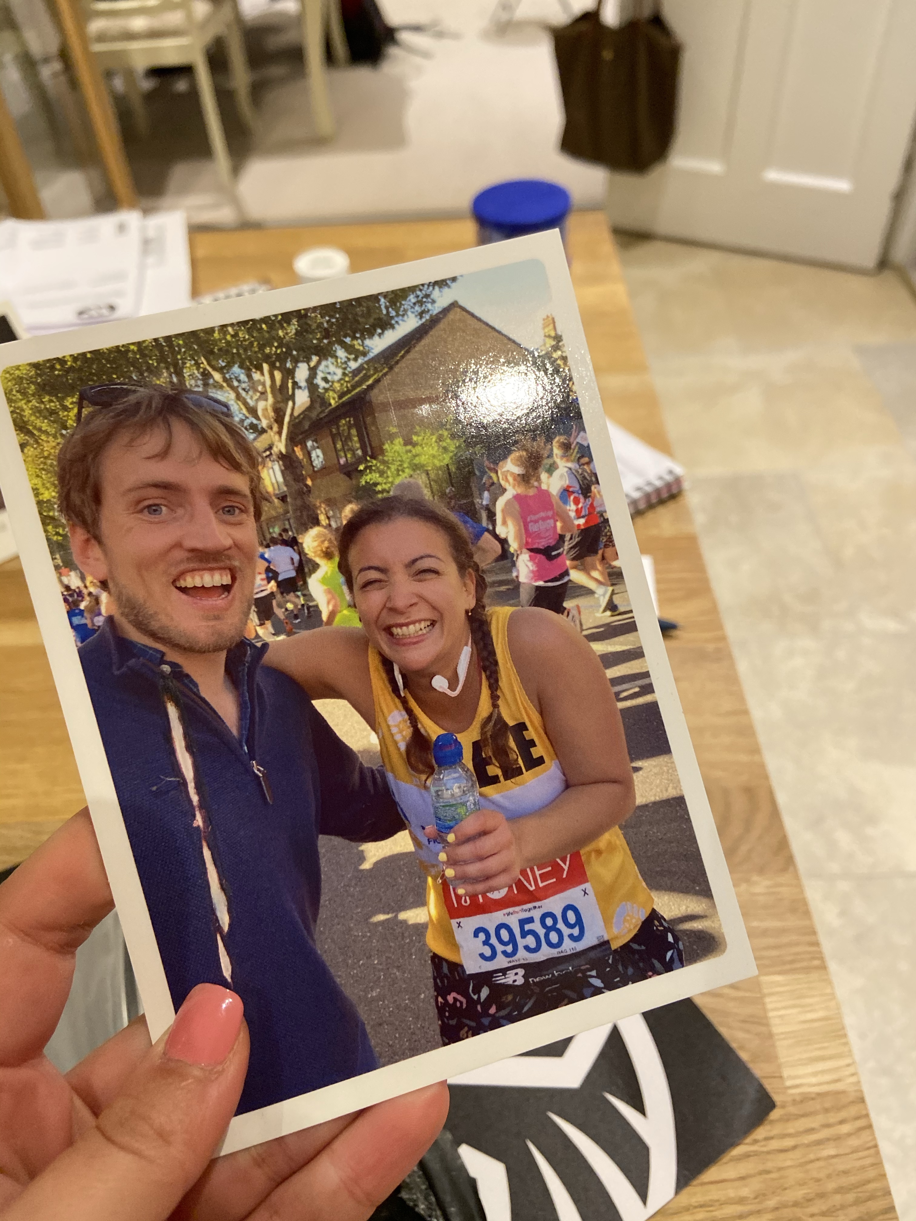 A postcard showing a man and a woman laughing in the street during the London Marathon
