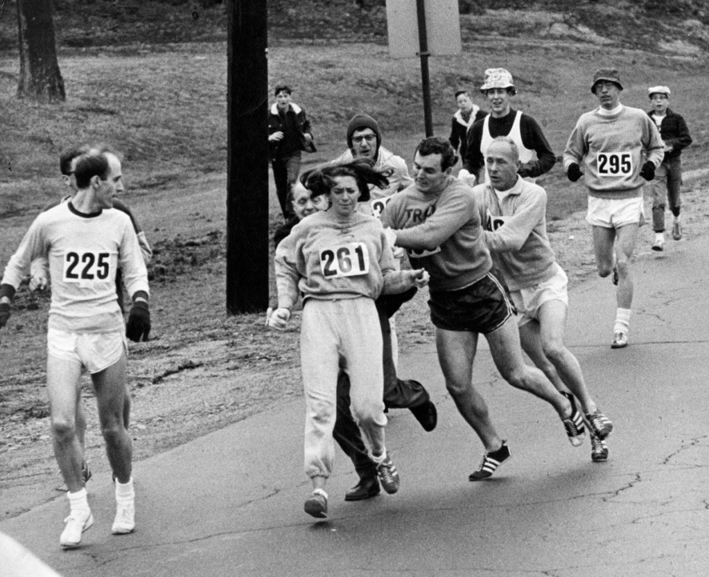 Kathrine Switzer being pushed by other competitors at the 1967 Boston Marathon