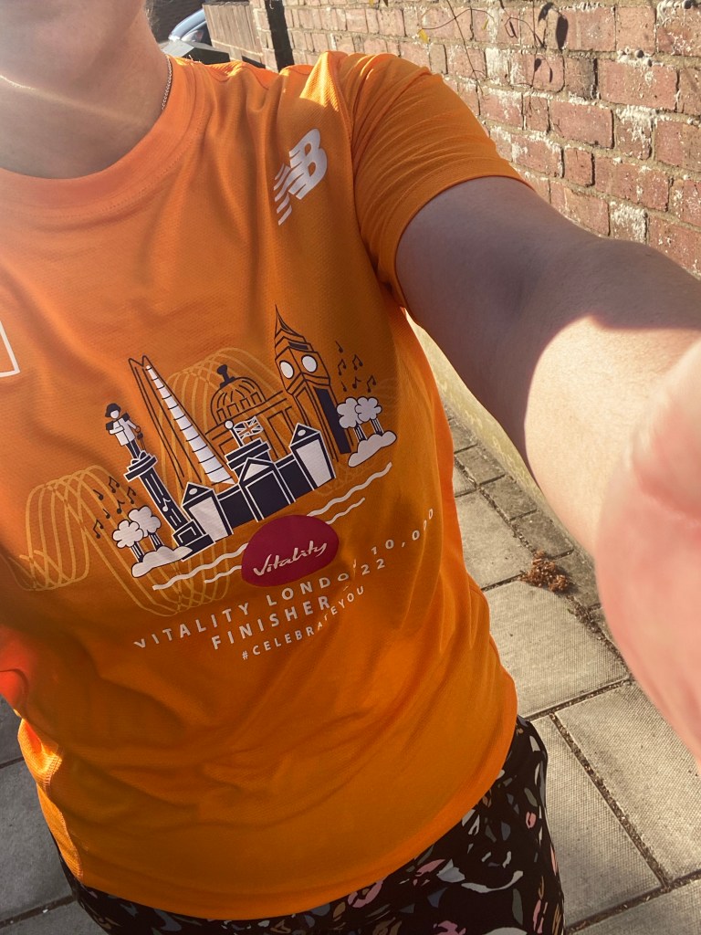 A girl wearing an orange running t-shirt from the Vitality London 10k race