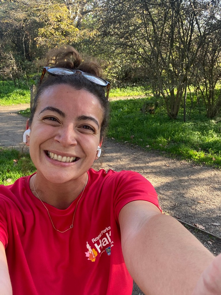 Girl in a park wearing a red running t-shirt and sunglasses 
