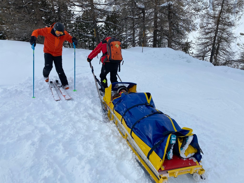 A photo of a girl being rescued from a snow covered mountain on a ski holiday in a ski stretcher